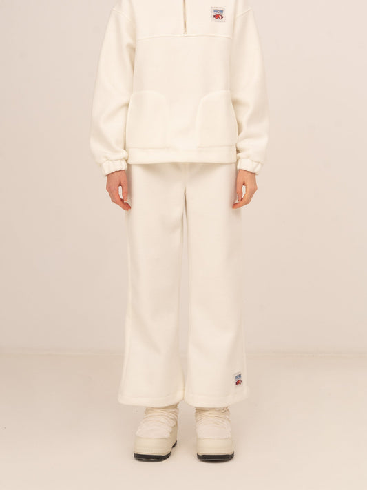 Pantalón femenino largo en color blanco con corte flare y tejido suave tipo polar, diseño cómodo y elegante con caída fluida, ideal para looks de invierno relajados, conjuntos après-ski o estilismos casuales con un toque sofisticado.
