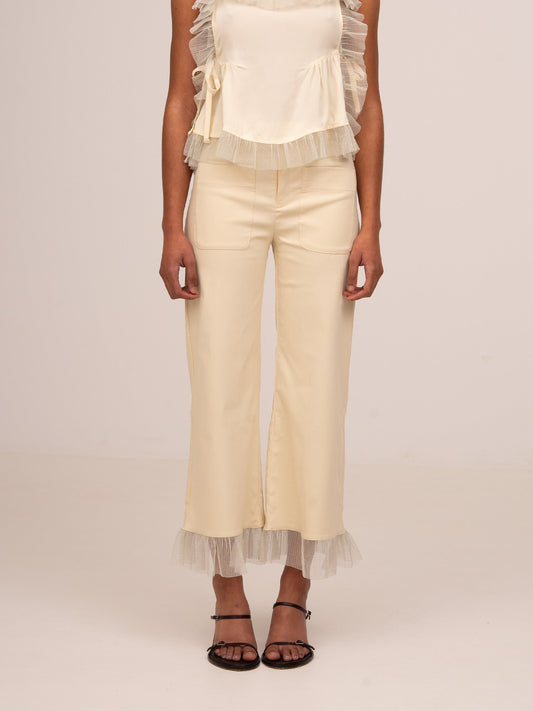 Pantalón crema de pierna ancha con cinturilla baja, bolsillos de parche y bajo con volante.