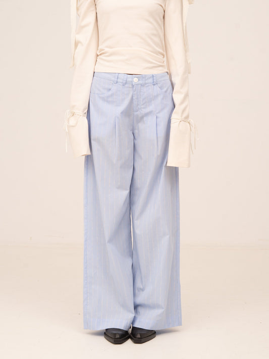 Pantalón largo de corte recto en color azul claro con tejido ligero y textura sutil, de estilo elegante y fluido.