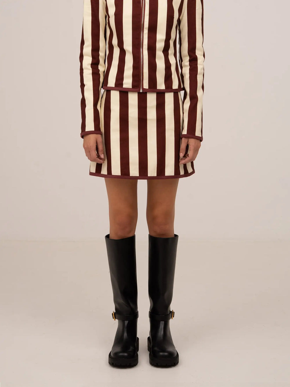 Falda mini con rayas verticales en tonos burdeos y crudo, corte recto y diseño ajustado.