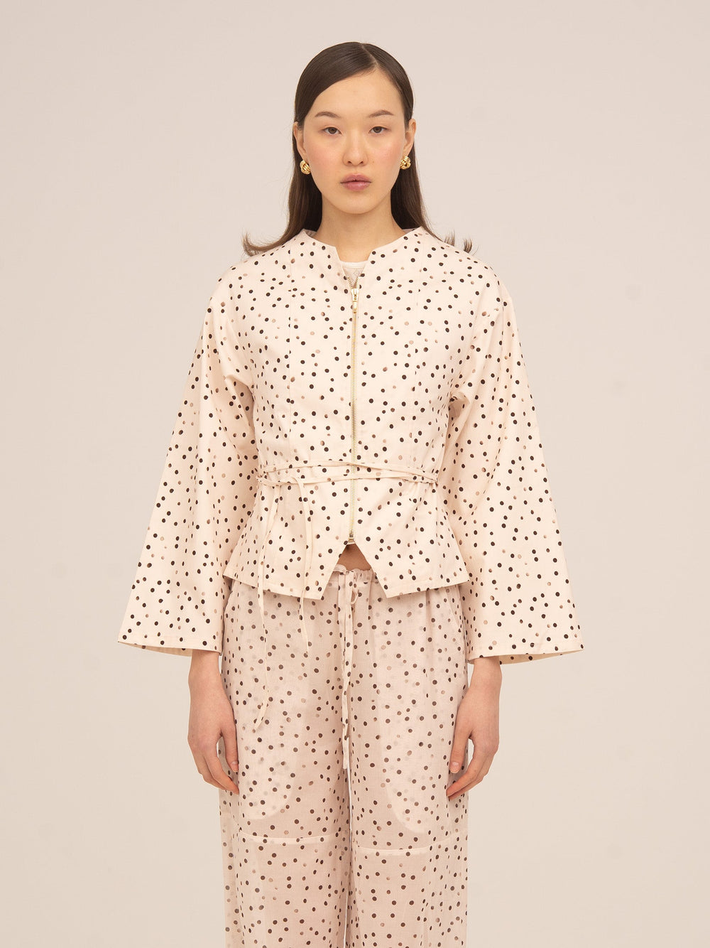 Chaqueta color crema con estampado de lunares negros de Carmen Says, diseño femenino con cinturón ajustable y manga amplia, ideal para conjuntos elegantes y looks sofisticados de temporada.