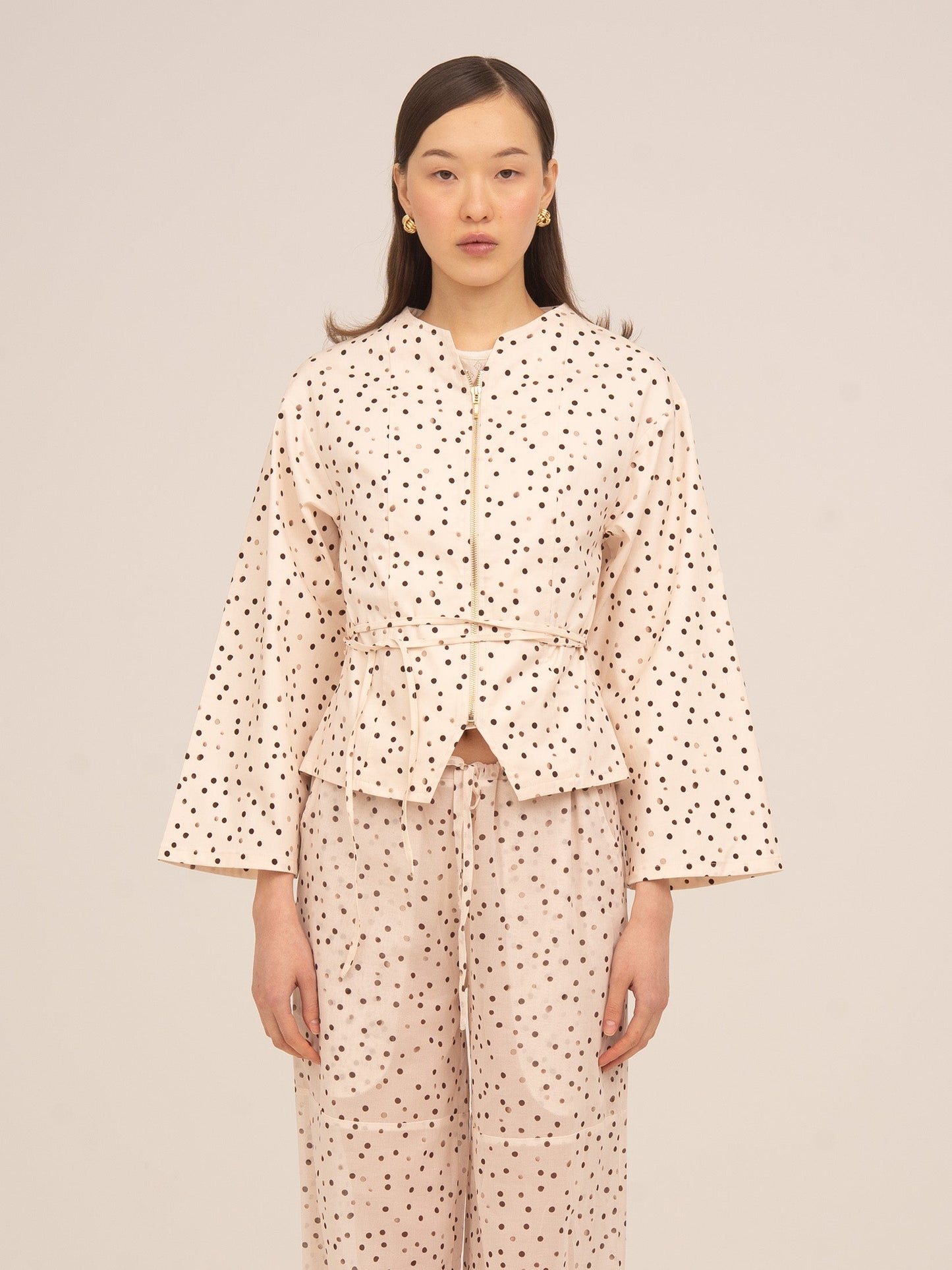 Chaqueta color crema con estampado de lunares negros de Carmen Says, diseño femenino con cinturón ajustable y manga amplia, ideal para conjuntos elegantes y looks sofisticados de temporada.