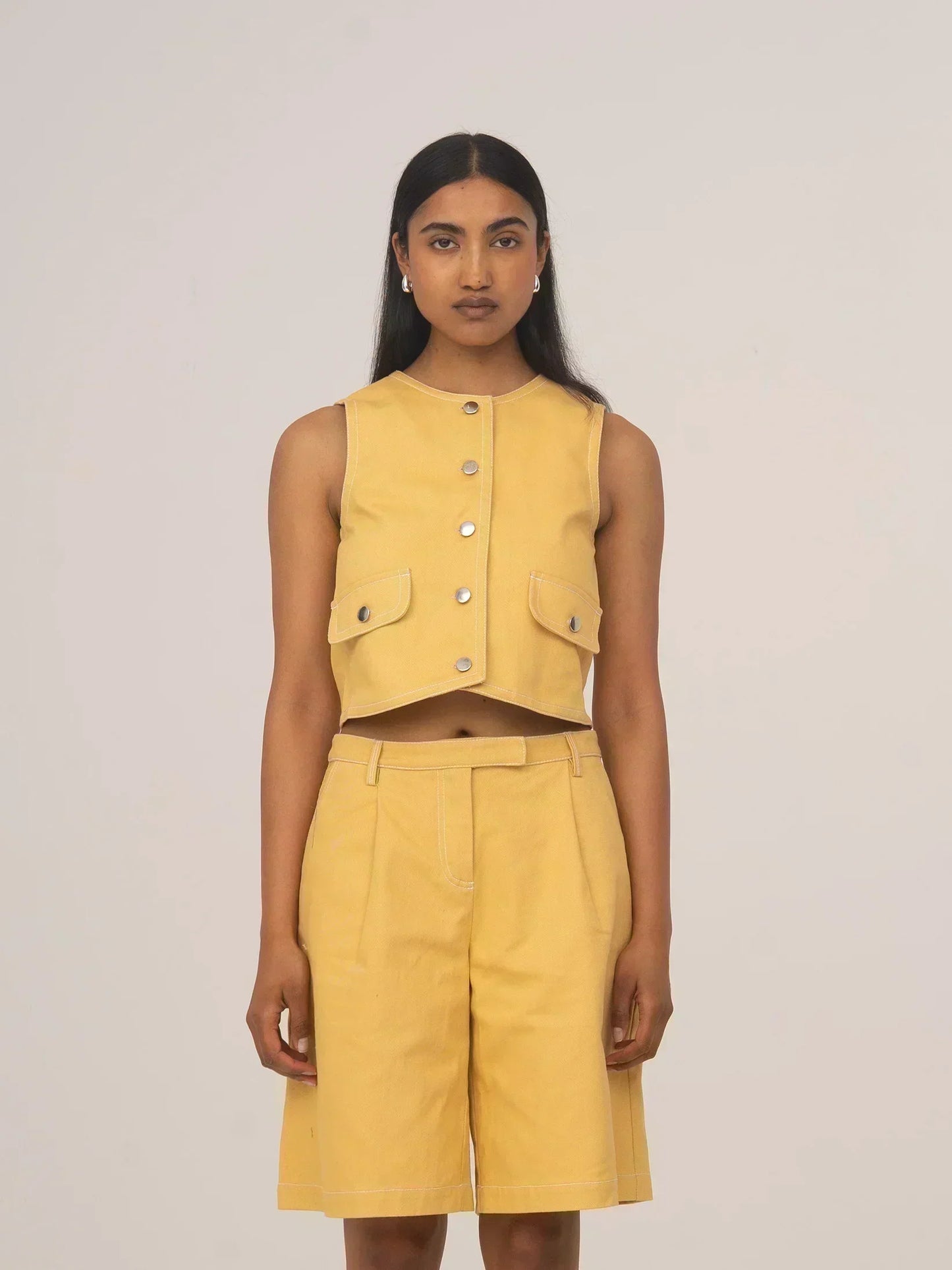 Modelo con chaleco corto de denim amarillo pálido con botones delanteros de CARMEN SAYS