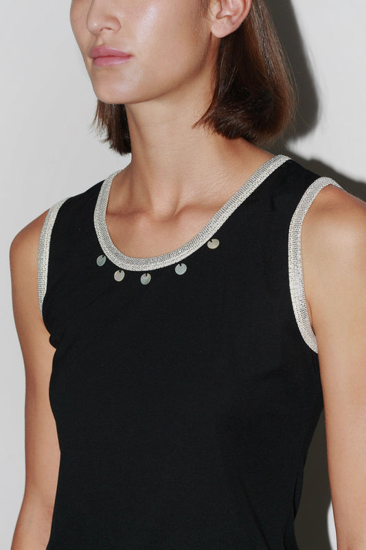 Close-up of the Jade Top – black sleeveless top with pearl-embellished neckline and elegant cut.