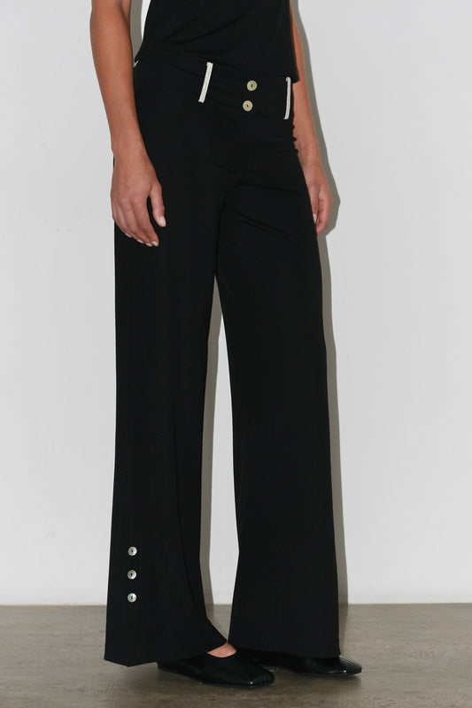 Close-up of the Zeynep Pants – high-rise fit with front seams and silver button embellishments.