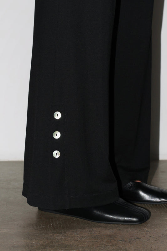 Detail shot – silver buttons and fine stitching highlighting Coloma’s craftsmanship.