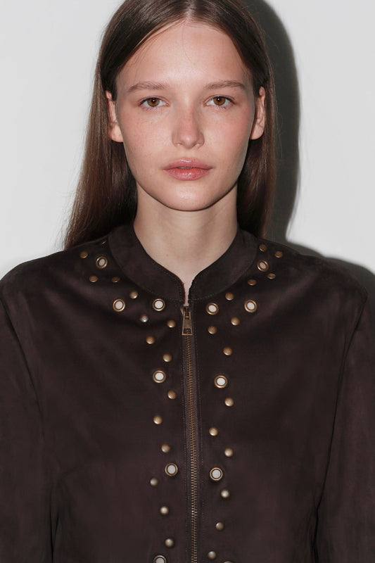 Close-up of the Bella Brown Jacket – textured brown fabric with detailed stitching and metallic button accents.