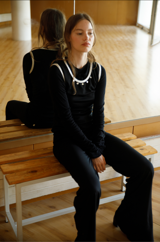 Lifestyle shot – woman sitting in the Zeynep Pants, polished and modern Coloma’s look.