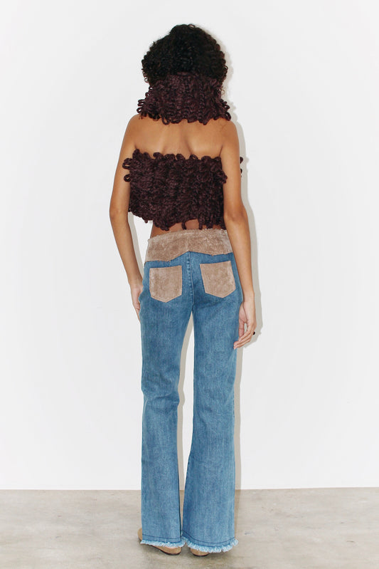 Back view of the Kika Pants – denim trousers featuring beige cut-out details and contrast stitching.