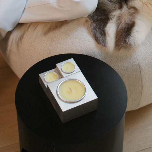 Collezione Aura Effusione, candele in alluminio magnetiche di design posizionate su tavolino in ambiente elegante e accogliente